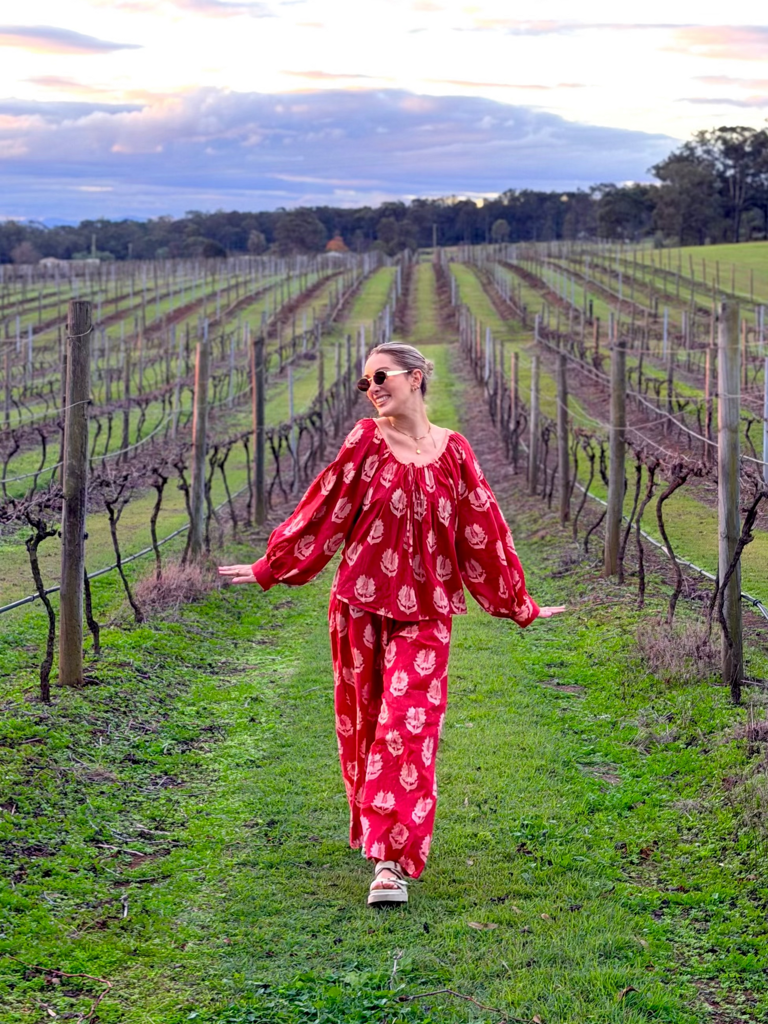 Maddie Pye, founder of The Girls Who Gather, walking through a vineyard on the Central Coast, NSW. Founder portrait representing the women's community dedicated to helping women build friendships and meaningful connections.